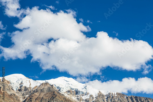 Mountain range next to Nanga Parbat mountain peak with clouds over them from Fairy Meadow. Gilgit, Pakistan