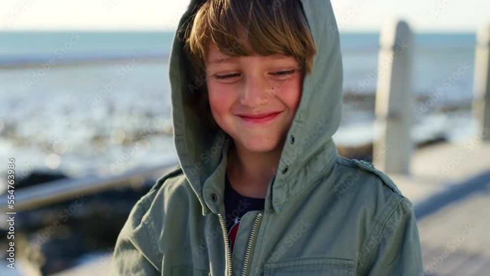 Child, face and smile on beach for travel holiday, winter vacation and freedom outdoor. Young boy, relax happiness and thinking on Bali ocean seaside traveling location or enjoying cold sunshine Child, face and smile on beach for travel holiday, winter vacation and freedom outdoor. Young boy, relax happiness and thinking on Bali ocean seaside traveling location or enjoying cold sunshine