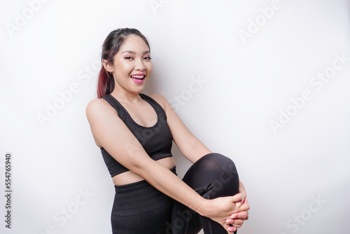 Portrait of young Asian sporty woman wearing sportswear is stretching out before training.