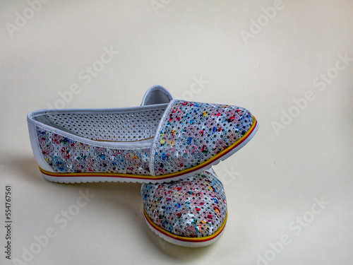 Female summer slippers with a beautiful motley pattern. A pair of beautiful light summer shoes female. Modern summer female shoes for walking outside the home