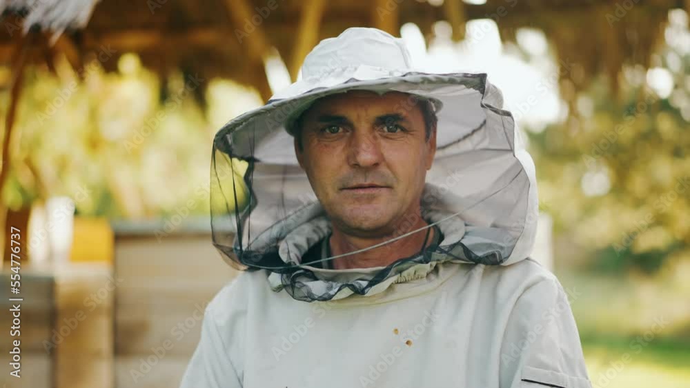 Portrait of an experienced cheerful beekeeper in protective gear. Portrait of an experienced cheerful beekeeper in protective gear.