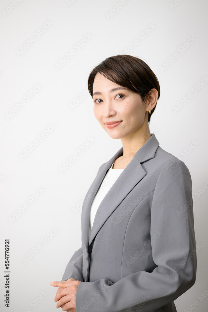 Image of a user-friendly business woman in a suit, looking at the camera Vertical Image of a user-friendly business woman in a suit, looking at the camera Vertical
