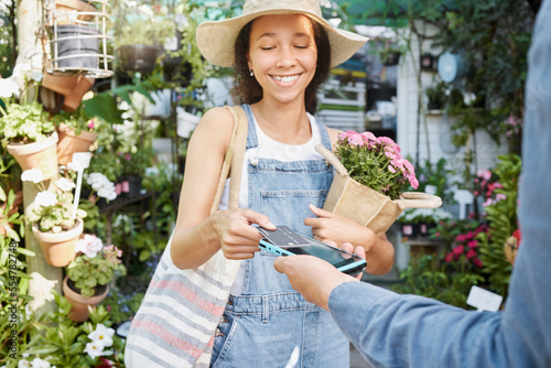 Payment, flower shopping and woman at a nursery, credit card tapping and machine for ecology at a small business. Paying, bouquet and girl buying flowers with a debit card at a shop for agriculture