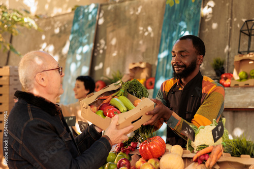 Canvastavla Senior man buying various fresh seasonal fruits and vegetables at farmers market in fall months
