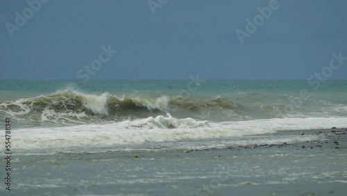 Waves in the raging sea in slow motion, in the background gloomy sky