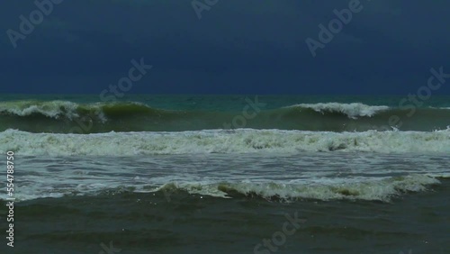 Waves in the raging sea in slow motion, in the background gloomy sky