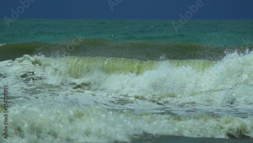 Waves in the raging sea in slow motion, in the background gloomy sky
