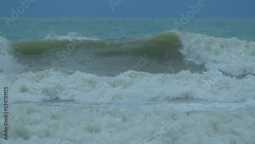 Waves in the raging sea in slow motion, in the background gloomy sky