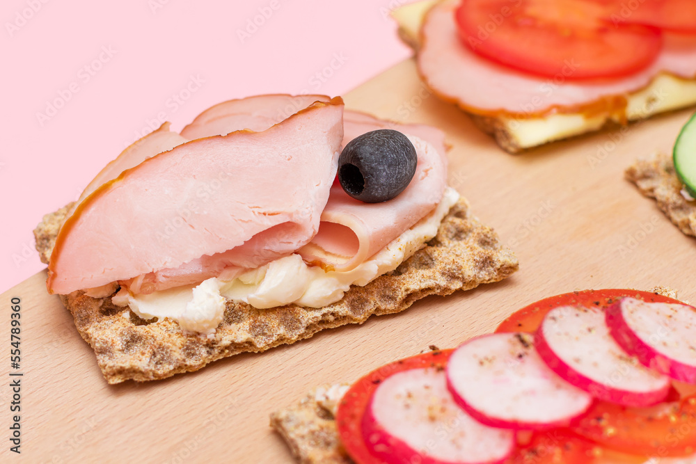 Different Whole Grain Crispbread with Ham, Tomato, Radish, Cucumber and Cheese. Easy Breakfast. Diet Food. Quick and Healthy Sandwiches. Crispbread with Tasty Filling. Healthy Dietary Snack