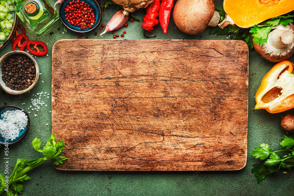 Obraz Food background. Rustic wooden cutting board. Vegetables, mushrooms, roots, spices - ingredients for vegan, cooking. Healthy eating, diet, comfort slow food. concept. Old kitchen table, top view fototapeta, plakat