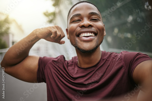 Selfie, smile and fitness arm flex of a black man athlete ready for running, workout and exercise. Training, happy and runner man portrait with motivation for sport, wellness and muscle health