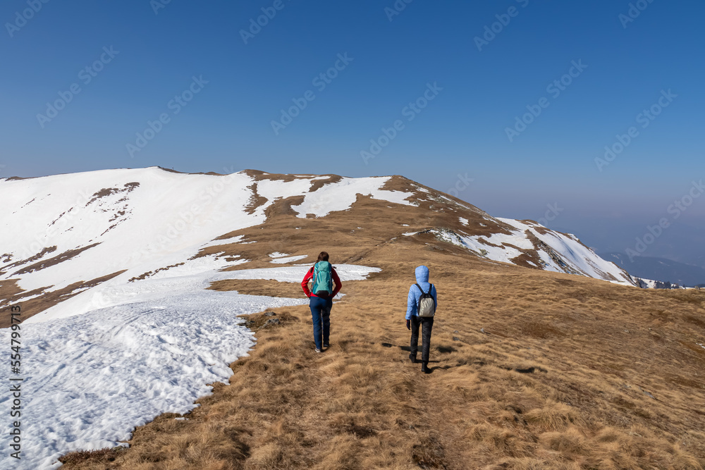 Two people on scenic ski tour hiking trail from Hohe Ranach to Zirbitzkogel and Kreiskogel, Seetal Alps, Styria (Steiermark), Austria, Europe. Snow covered idyllic mountain ridges on sunny winter day