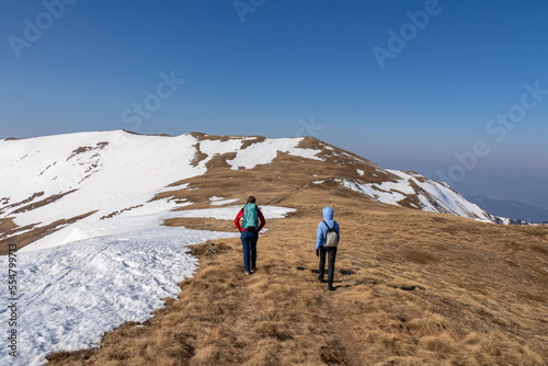 Two people on scenic ski tour hiking trail from Hohe Ranach to Zirbitzkogel and Kreiskogel, Seetal Alps, Styria (Steiermark), Austria, Europe. Snow covered idyllic mountain ridges on sunny winter day