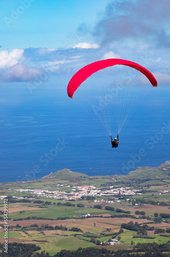 Paragleiter nach dem Start vom Pico Barrosa mit Blick über die Insel Sao Miguel, Azoren, Portugal,