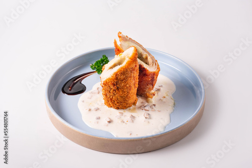 cordon bleu dish in sauce on a white background