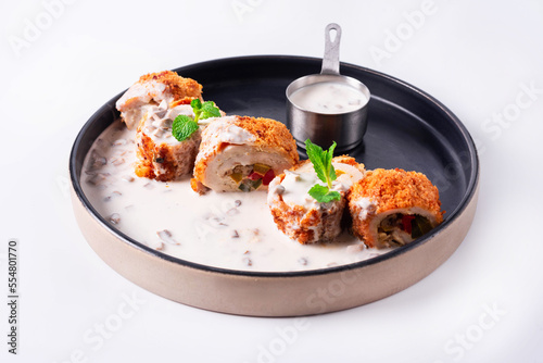 chicken meat rolls with stuffing and sauce on a white background