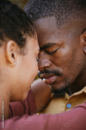 Love, intimate and black couple hugging on a date for romance, care and intimacy together. Romantic, loving and young African man and woman embracing on a summer honeymoon vacation, holiday or trip.