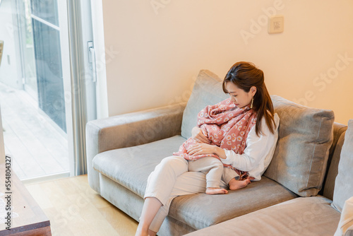 ソファーで赤ちゃんに授乳をするお母さん