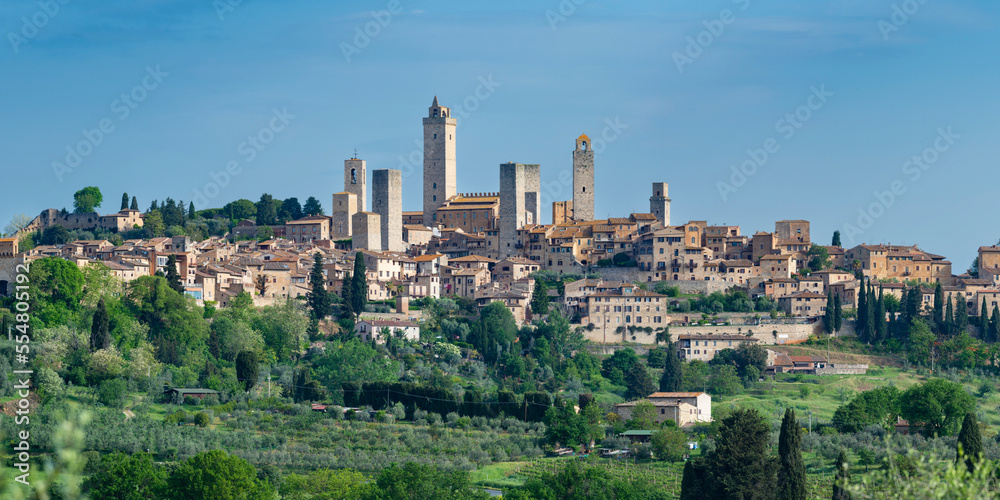 Italy, Tuscany, San Gimignano, Green trees in front of medieval town in summer Italy, Tuscany, San Gimignano, Green trees in front of medieval town in summer