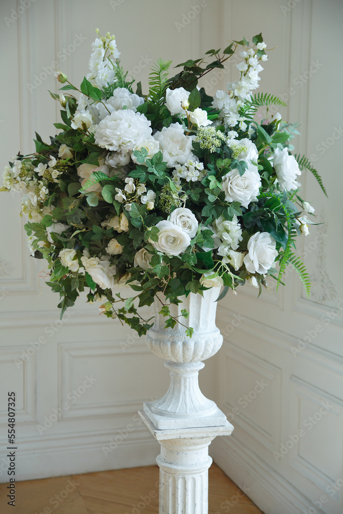 Chic interior flower arrangement in a vase of white artificial roses.