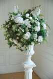 Chic interior flower arrangement in a vase of white artificial roses.