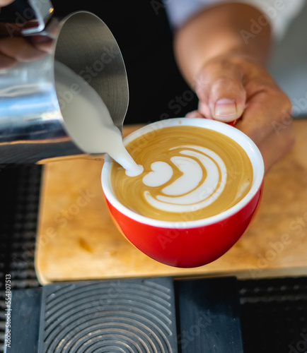 how to make coffee latte art by barista focus in milk and coffee cup in cafe shop