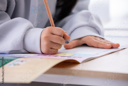 宿題をする小学生の女の子（顔無し）