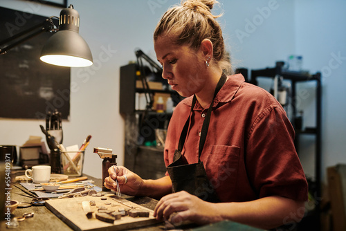 Jeweller working at workbench in workshop photo