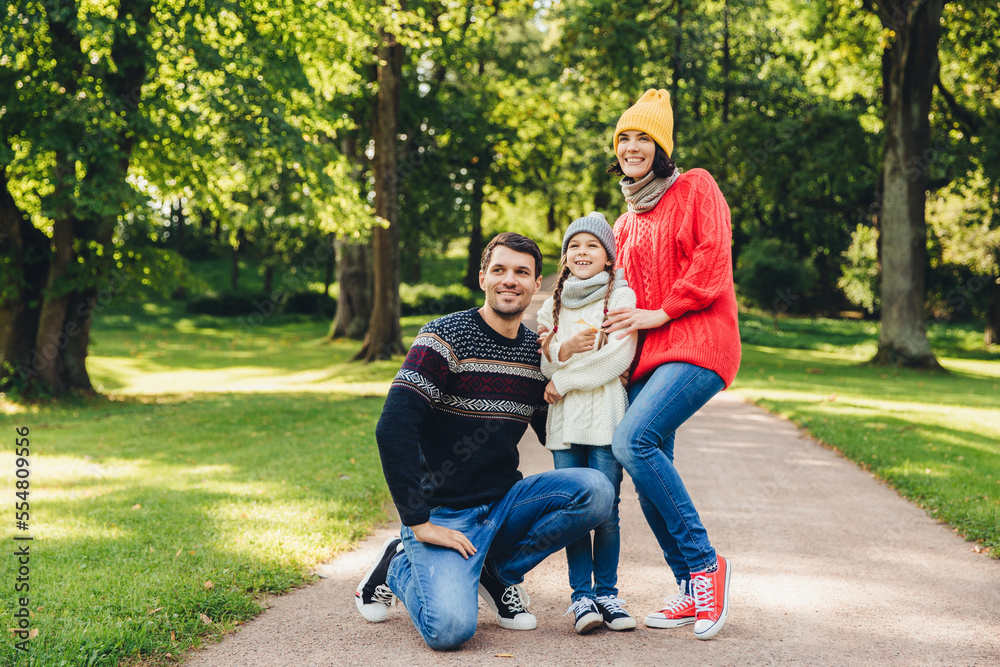 Carefree restful family have walk together, enjoy sunny autumn weather, green beautiful park and fresh air, pose into camera, embrace each other, have model relationship. Joyful child and parents Carefree restful family have walk together, enjoy sunny autumn weather, green beautiful park and fresh air, pose into camera, embrace each other, have model relationship. Joyful child and parents