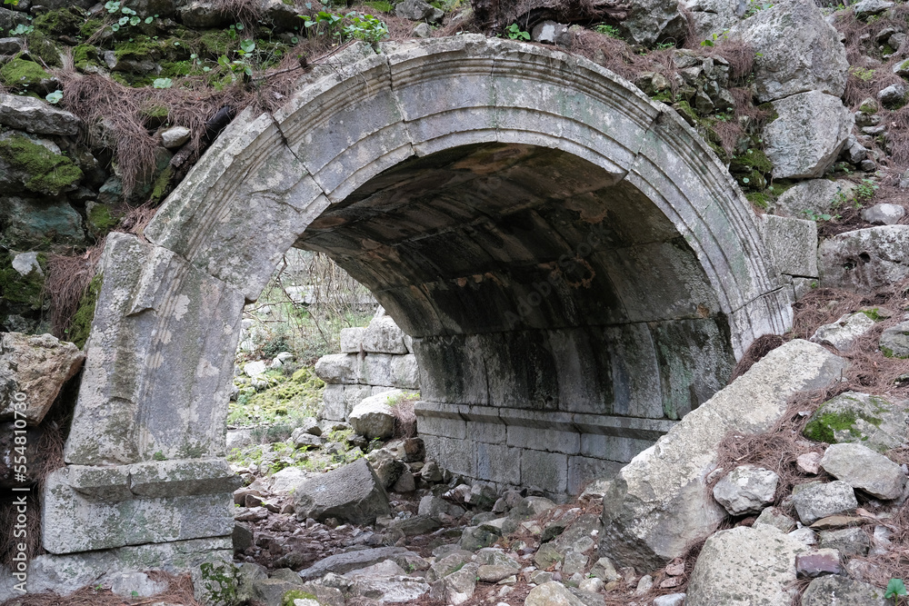 Remains of Olympos Ancient City on cloudy winter day. Entrace to roman theatre. Turkey.