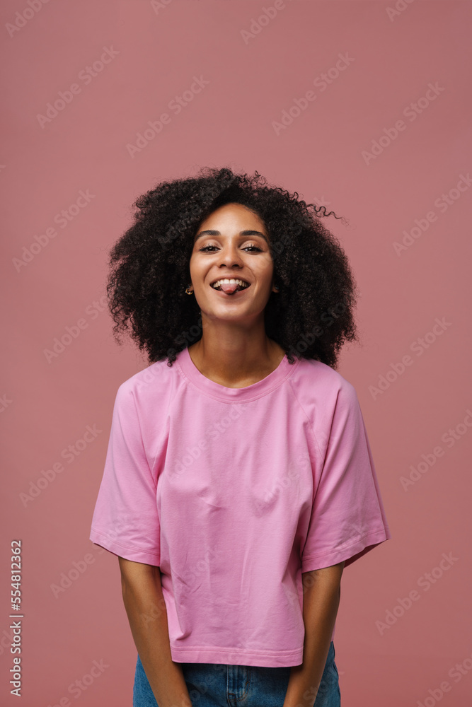 Portrait of young beautiful smiling happy curly woman showing tongue Portrait of young beautiful smiling happy curly woman showing tongue