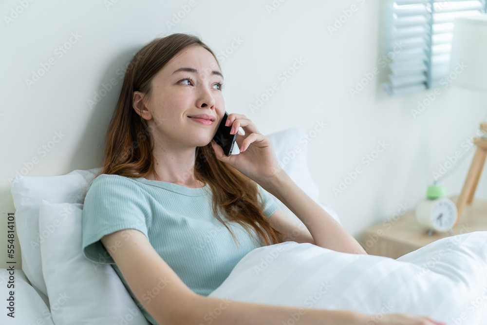 Young Caucasian woman use mobile phone call on bed at home in morning. Young Caucasian woman use mobile phone call on bed at home in morning.