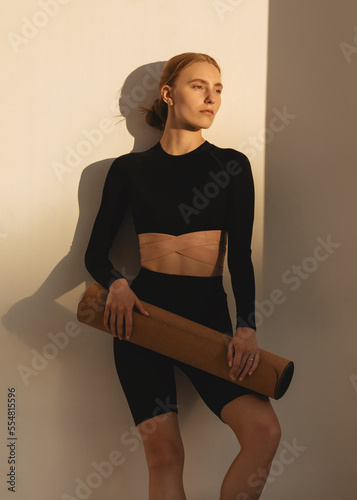 Wellness exercise, woman on floor mat stretching alone, workout day. Fitness training motivation in sunlight, health instructor stretching  and athlete balance lifestyle
