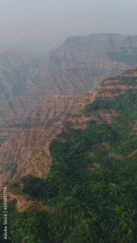 Vertical video of Aerial shot of valleys between steep rocky hills, green vegetation on top Vertical video of Aerial shot of valleys between steep rocky hills, green vegetation on top