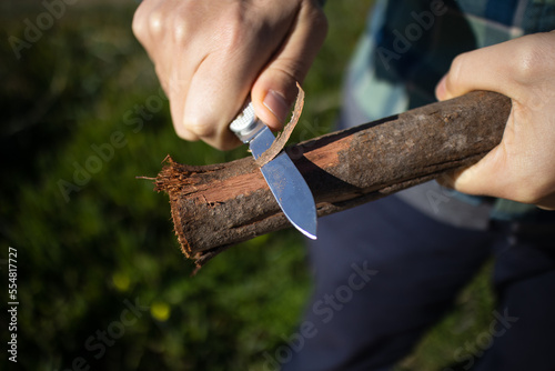 Person Feathering Wood with Multitool Pocket Knife photo