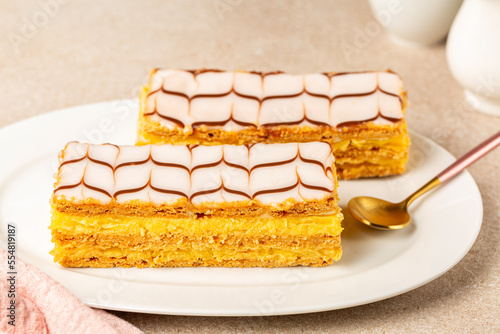 The mille-feuille  or millefeuille  is a piece of French pastry made from three layers of puff pastry and two layers of pastry cream. The top of dessert is iced with icing sugar.