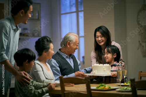 senior asian couple celebrating wedding annversary with three generational family © imtmphoto