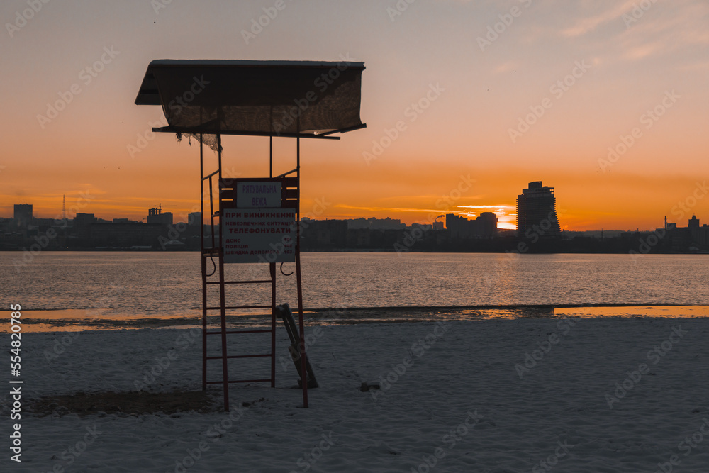 Beautiful winter view of the city of Dnipro during sunset or sunrise. Winter landscape. Ukrainian city. The lights of a sun. Calm nature copies the space background.