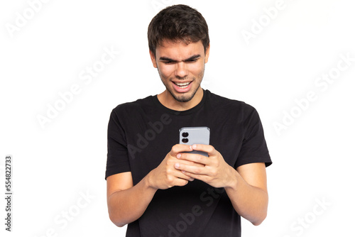 Impressed young man using phone. Frowned Caucasian male model with short dark hair in black T-shirt smiling, looking at screen, watching video or receiving message. Modern technology concept © KAMPUS