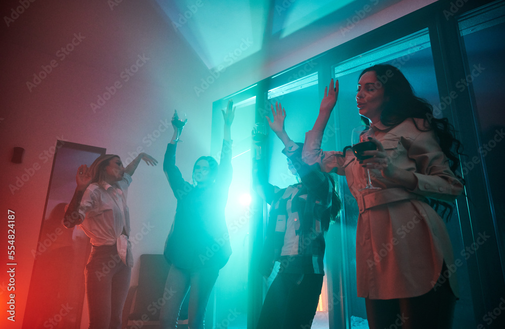 Young women having party inside contemporary barn house at night.