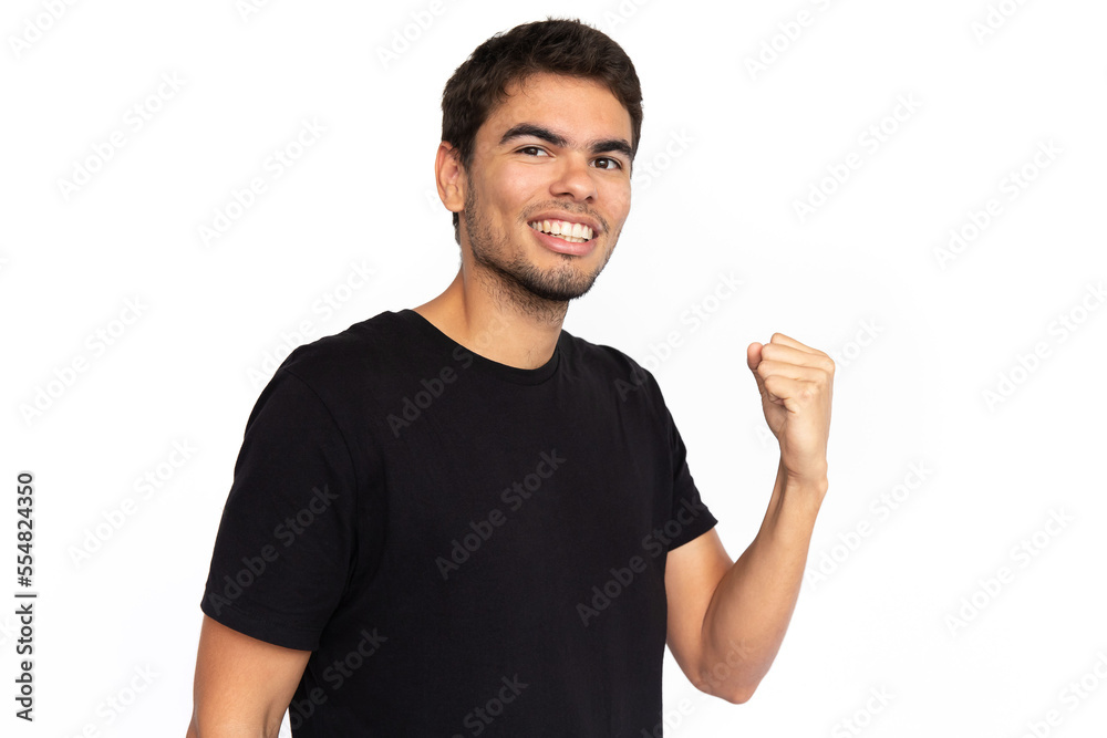 Happy young man with clenched fist. Portrait of cheerful Caucasian male model with short dark hair in black T-shirt looking at camera with winner gesture, celebrating success. Achievement concept Happy young man with clenched fist. Portrait of cheerful Caucasian male model with short dark hair in black T-shirt looking at camera with winner gesture, celebrating success. Achievement concept