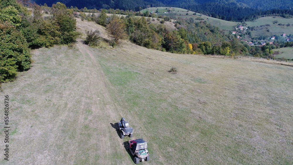 Aerial drone view of ATV quads on a dirt trail in forests. Off-road group team club enthusiasts having fun while driving countryside roads. Aerial drone view of ATV quads on a dirt trail in forests. Off-road group team club enthusiasts having fun while driving countryside roads.