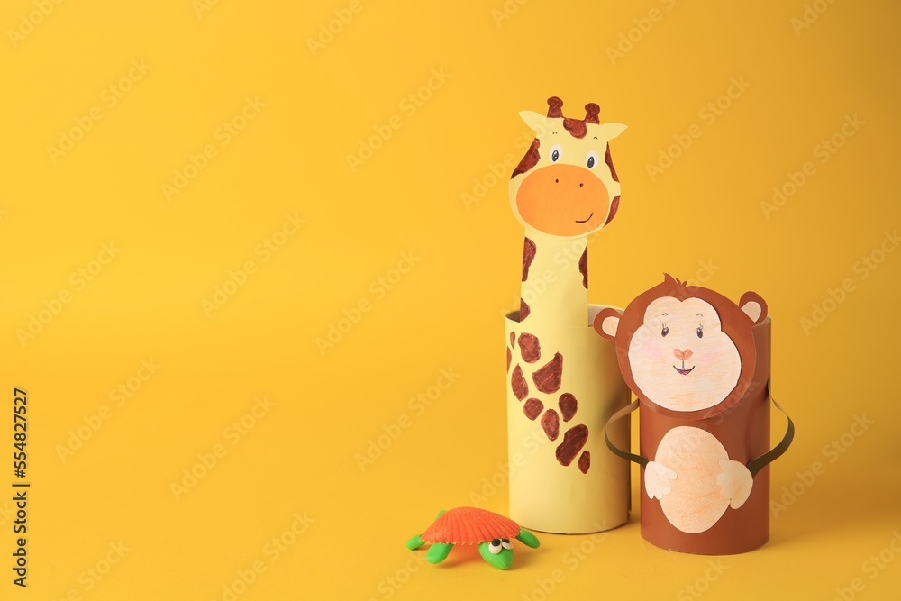 Toy monkey and giraffe made from toilet paper hubs with plasticine turtle on yellow background, space for text. Children's handmade ideas Toy monkey and giraffe made from toilet paper hubs with plasticine turtle on yellow background, space for text. Children's handmade ideas