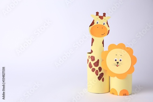 Toy giraffe and lion made from toilet paper hubs on white background  space for text. Children s handmade ideas