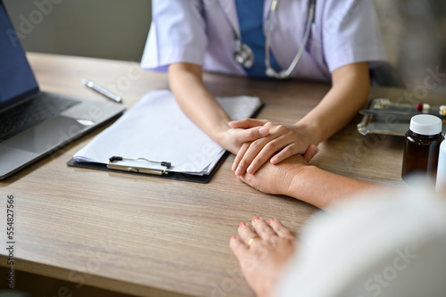 close-up image  A female doctor holds a patient s hand to comfort and reassure the patient