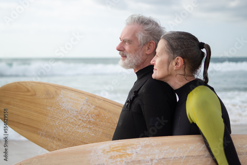Photography Side view of happy aged couple surfing together