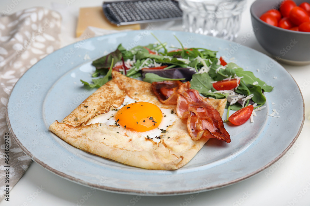 Delicious crepe with egg on white table. Breton galette Delicious crepe with egg on white table. Breton galette