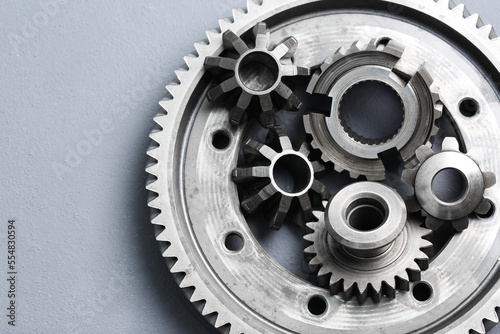 Different stainless steel gears on light grey background, top view