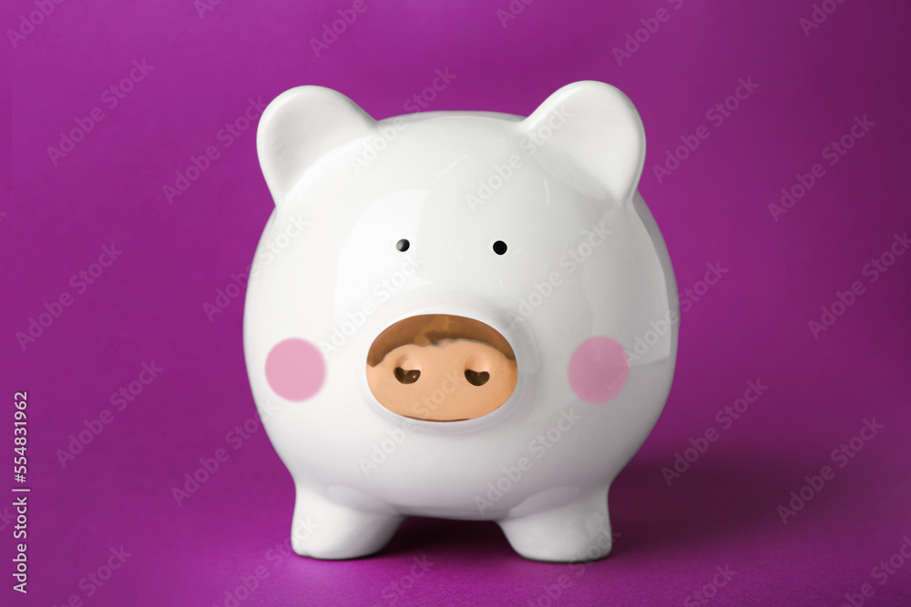 Ceramic piggy bank on purple background. Financial savings Ceramic piggy bank on purple background. Financial savings