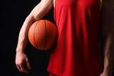 Athletic man with basketball ball on black background, closeup